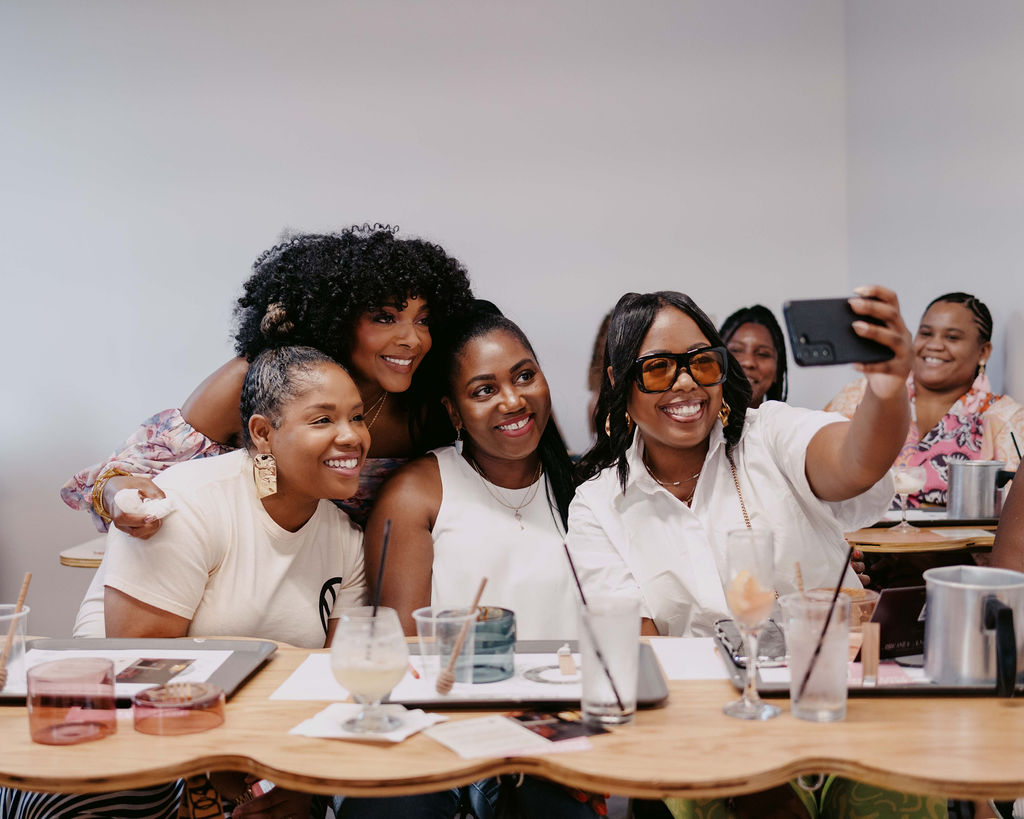 Marie Cloud and guests taking a selfie and sharing smiles during the Aroma & Ambiance event by Indigo Pruitt Designs, capturing a joyful moment