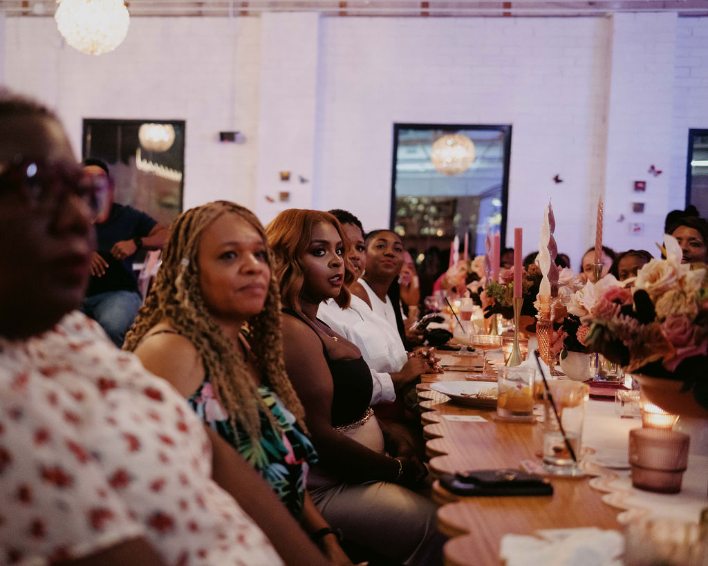 Attendees attentively listening during the design talk at the Aroma & Ambiance event by Indigo Pruitt Designs, seated at beautifully decorated tables